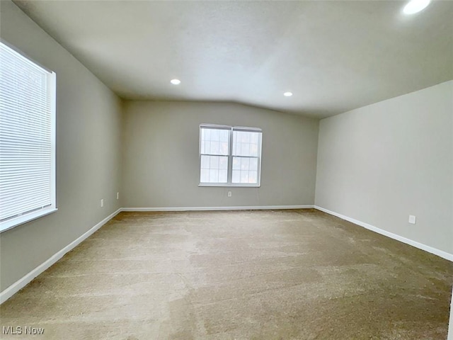 carpeted empty room with lofted ceiling