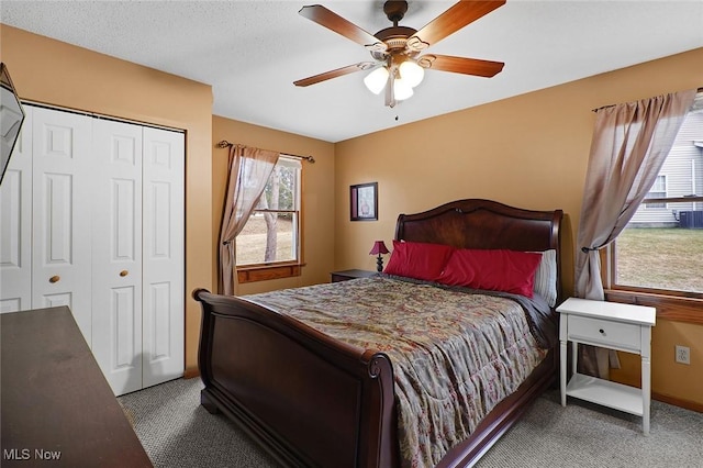 bedroom with ceiling fan, a closet, and dark colored carpet