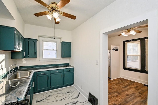 kitchen with decorative backsplash, green cabinetry, a healthy amount of sunlight, and sink