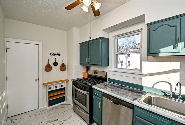 kitchen with appliances with stainless steel finishes, backsplash, a textured ceiling, ceiling fan, and sink