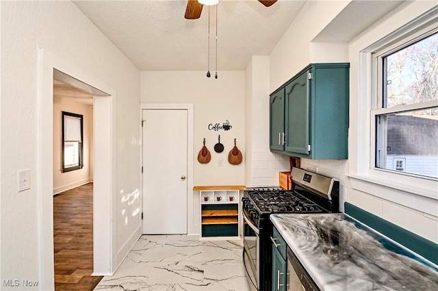 kitchen with a textured ceiling, stainless steel gas stove, tasteful backsplash, and ceiling fan