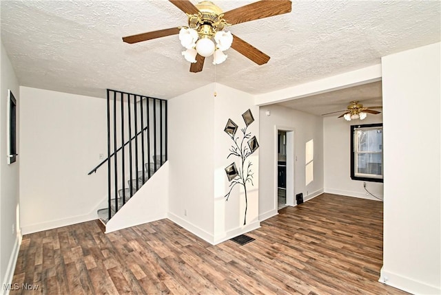 empty room with hardwood / wood-style flooring, ceiling fan, and a textured ceiling