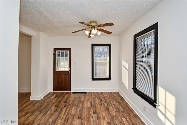 foyer featuring a textured ceiling, ceiling fan, and dark wood-type flooring