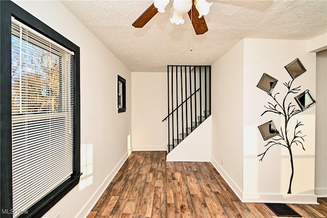 hall with wood-type flooring and a textured ceiling