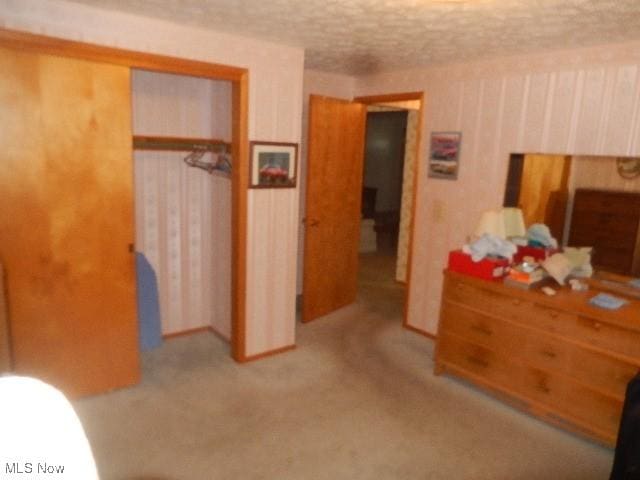 bedroom with a textured ceiling and a closet