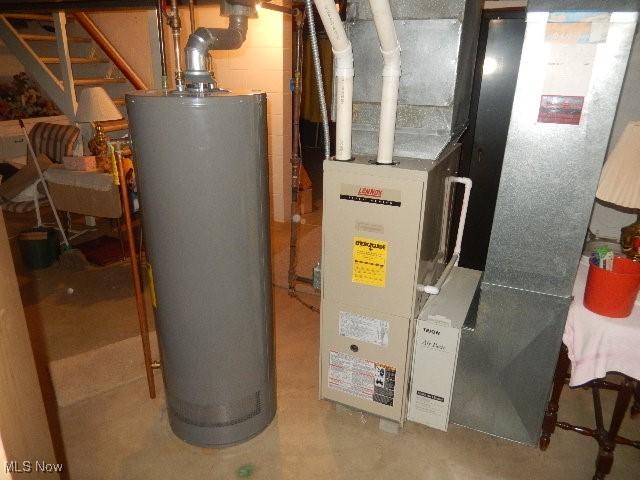 utility room featuring heating unit and gas water heater