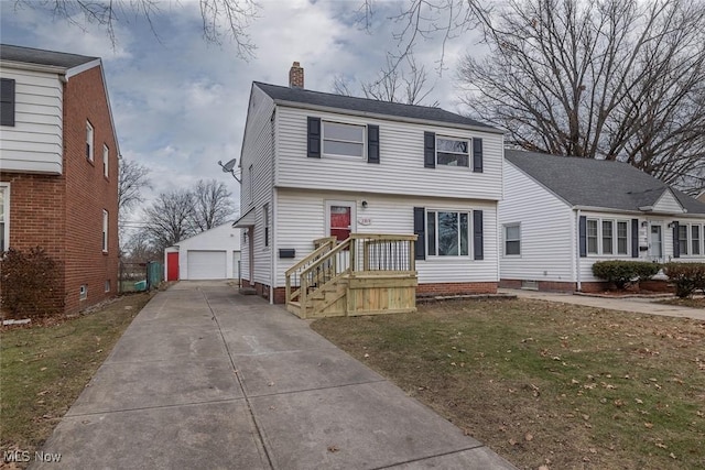 view of front of house featuring a garage, a front lawn, and an outdoor structure