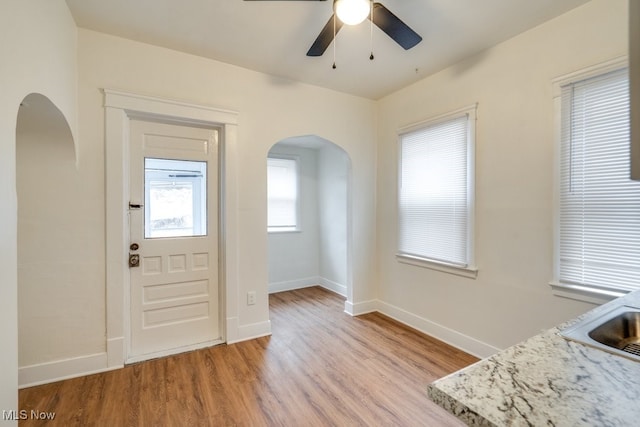 foyer with ceiling fan, light wood-type flooring, and sink