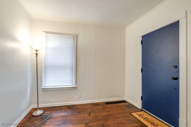 interior space featuring ornamental molding and dark wood-type flooring