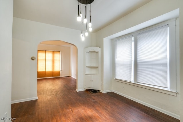 unfurnished dining area with dark wood-type flooring