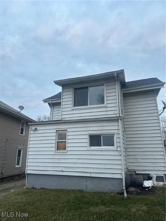 rear view of property featuring a lawn