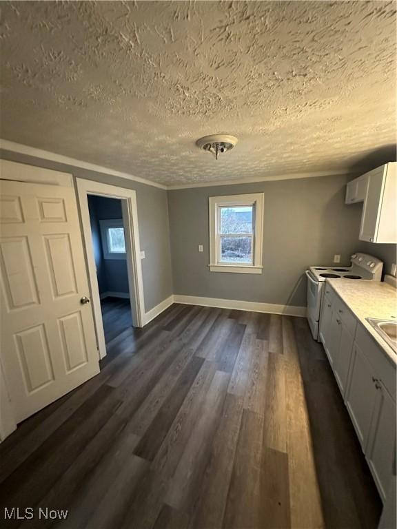 unfurnished dining area featuring a textured ceiling and dark hardwood / wood-style floors