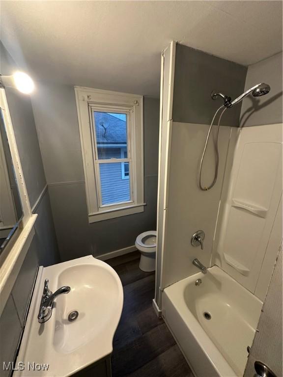 full bathroom featuring sink, hardwood / wood-style floors, bathtub / shower combination, and toilet