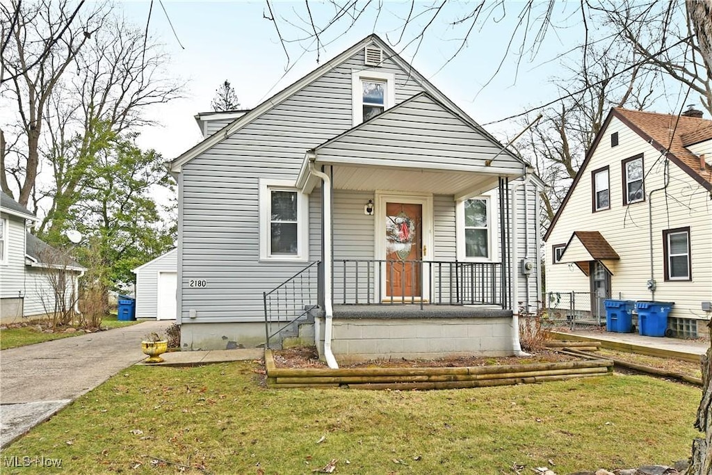 bungalow with a garage, an outbuilding, and a front yard