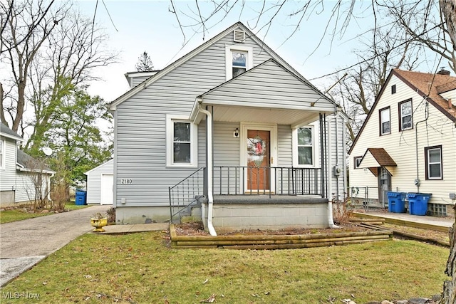 bungalow with a garage, an outbuilding, and a front yard