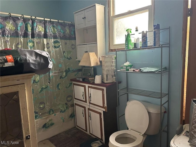 bathroom with toilet and shower / bathtub combination with curtain