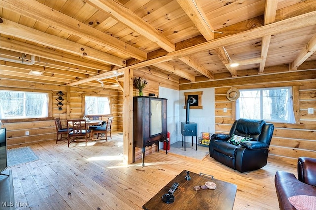 living room with beam ceiling, rustic walls, a wealth of natural light, and wood ceiling