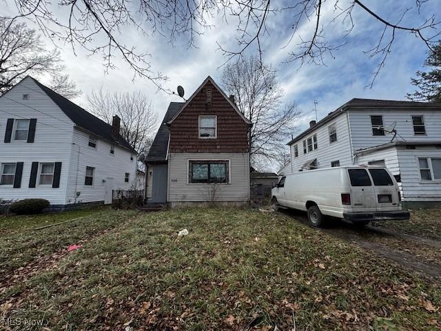 rear view of property featuring a lawn