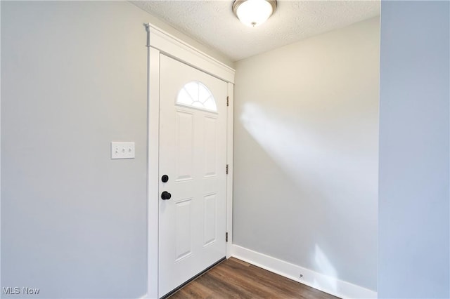 entrance foyer with dark hardwood / wood-style flooring and a textured ceiling