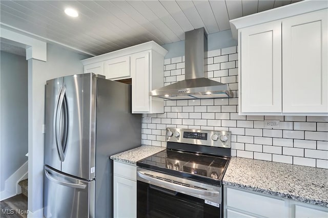 kitchen with white cabinets, appliances with stainless steel finishes, and wall chimney range hood