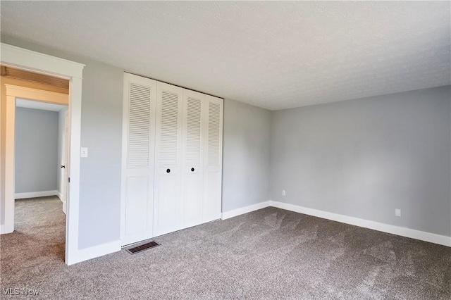 unfurnished bedroom featuring a closet, carpet, and a textured ceiling