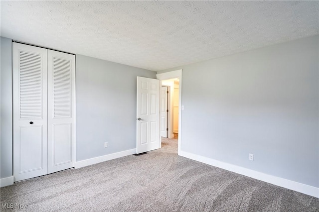 unfurnished bedroom featuring a closet, light colored carpet, and a textured ceiling