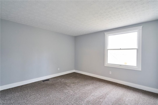 carpeted spare room featuring a textured ceiling