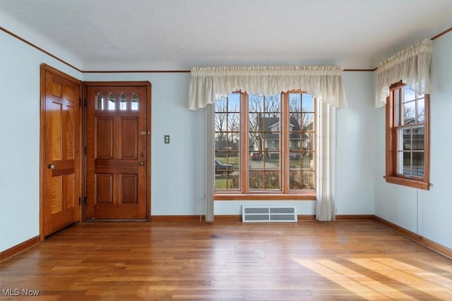 foyer featuring ornamental molding and hardwood / wood-style flooring