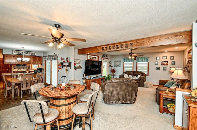 carpeted dining room with ceiling fan with notable chandelier and a textured ceiling