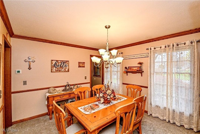 dining area featuring carpet flooring, ornamental molding, and a notable chandelier