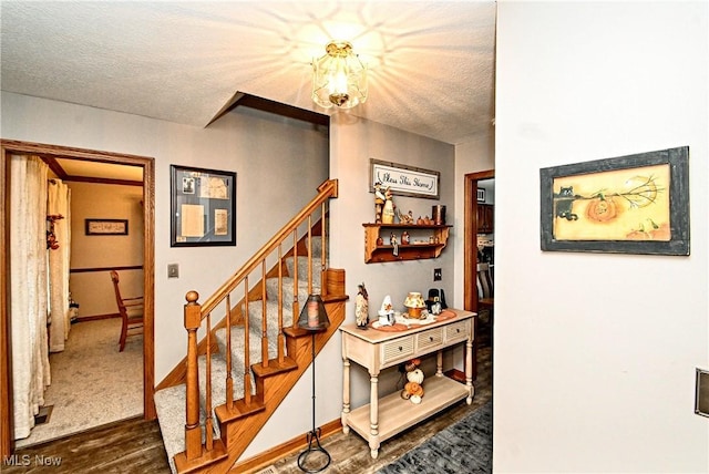 stairs with a textured ceiling and hardwood / wood-style flooring