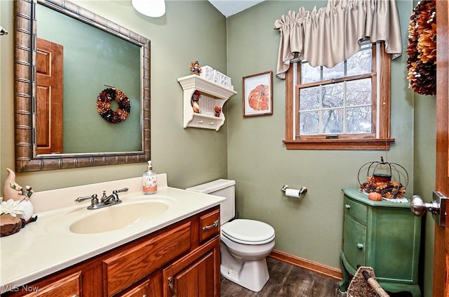 bathroom with hardwood / wood-style flooring, vanity, and toilet