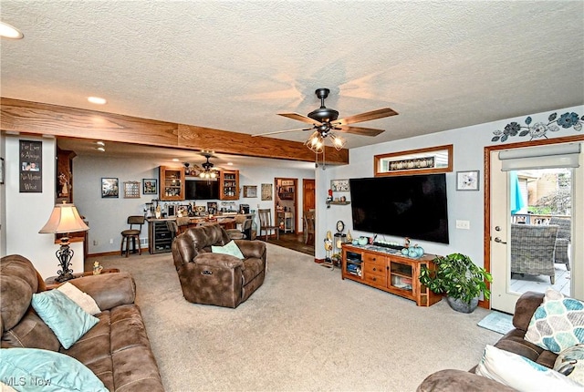 living room featuring ceiling fan, carpet, and a textured ceiling