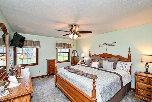 carpeted bedroom featuring a textured ceiling and ceiling fan