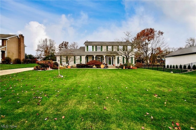 colonial inspired home featuring a front lawn