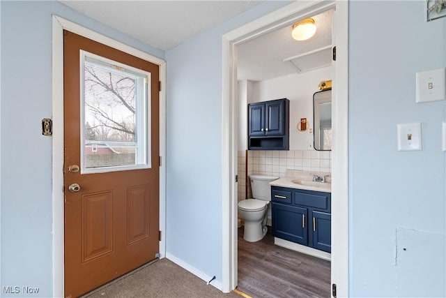 bathroom with vanity, backsplash, hardwood / wood-style flooring, and toilet