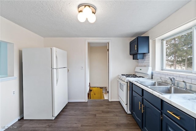 kitchen featuring decorative backsplash, white appliances, sink, and blue cabinets