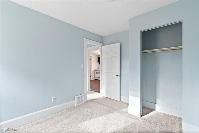 unfurnished bedroom featuring carpet flooring and a closet