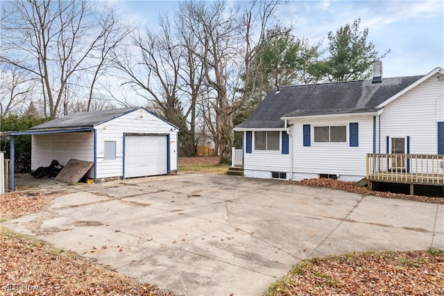 back of house with an outbuilding, a garage, and a wooden deck