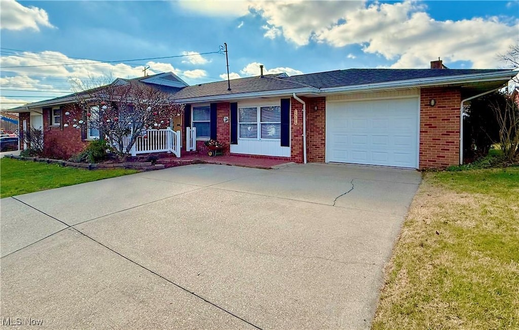 single story home featuring a front lawn and a garage