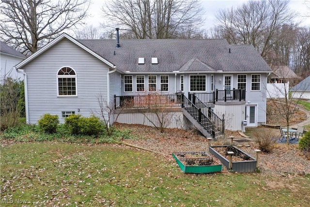 rear view of property with a lawn and a wooden deck