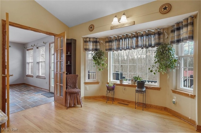 interior space with hardwood / wood-style flooring and vaulted ceiling