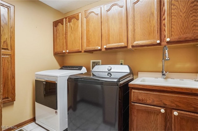 laundry room featuring cabinets, washing machine and dryer, light tile patterned floors, and sink