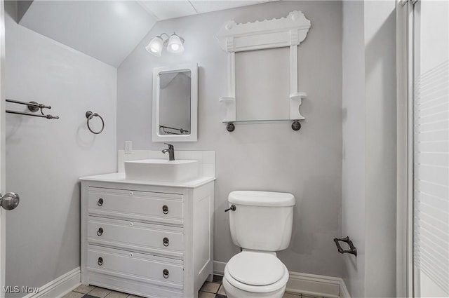 bathroom featuring tile patterned flooring, vanity, vaulted ceiling, and toilet