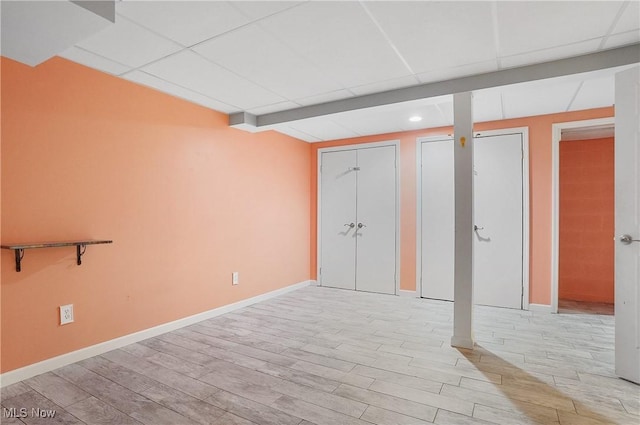 interior space with a drop ceiling and light wood-type flooring