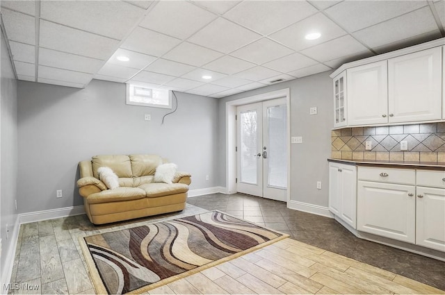 living room featuring french doors and a paneled ceiling