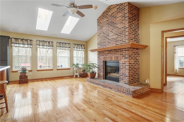 unfurnished living room featuring ceiling fan, a fireplace, hardwood / wood-style floors, and lofted ceiling