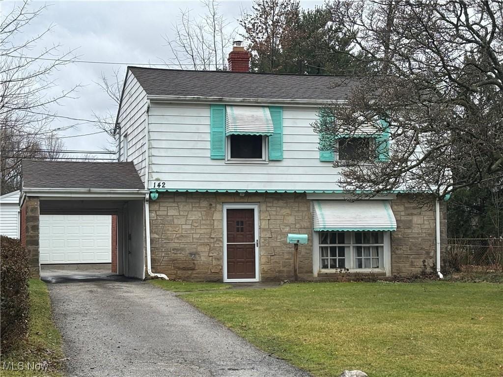 view of front of house with a front yard and a garage