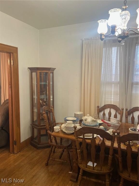 dining space with wood-type flooring and a notable chandelier