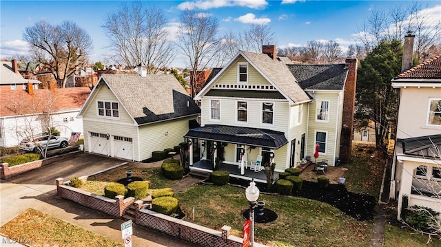 view of front of property with a garage, covered porch, and a front yard